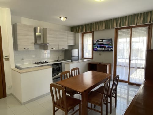 Cucina e zona pranzo moderna negli Aparthotel Rigiariloo, San Giacomo degli Schiavoni con tavolo in legno e vista sul mare