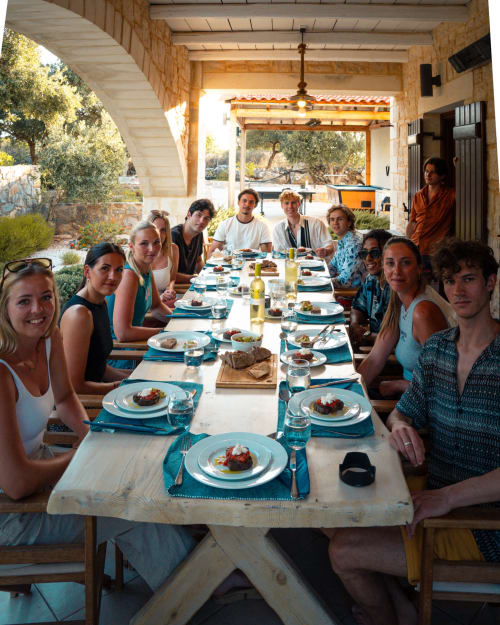 Group dining at Villa Freedom table in Kokkino Chorio, Crete with Mediterranean views