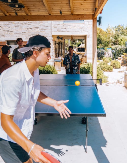 Guest playing ping pong at Villa Freedom outdoor recreation area in Kokkino Chorio, Crete