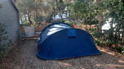 Tente pop-up bleue dans le jardin du camping La Lézardière à La Valette du Var, avec arbres et mobilier de jardin