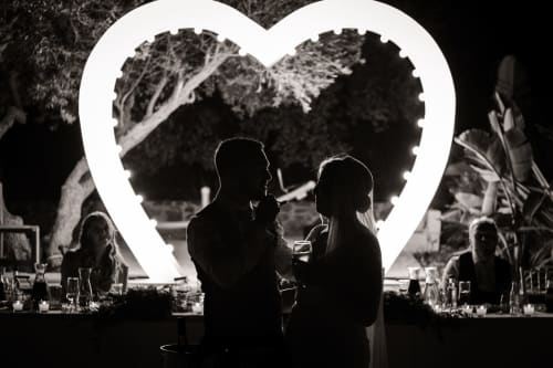Couple dancing under illuminated heart at Villa Freedom wedding reception, Crete