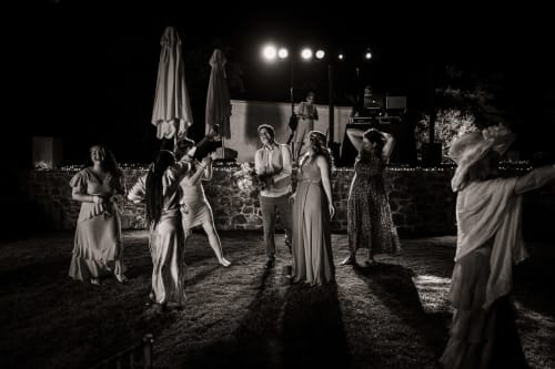 Nighttime wedding reception at Villa Freedom in Crete with guests dancing under lights on outdoor terrace