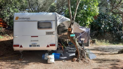Caravane Sterckeman stationnée au Camping La Lézardière à La Valette du Var, entourée d'arbres et d'espace vert