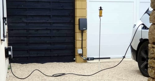 Station de recharge EV aux Secrets de Winna en Deux-Sèvres, voiture blanche connectée au chargeur dans l'allée