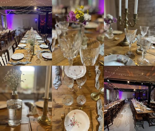 Elegante montaje de mesa en Domaine de l'Ocrerie con iluminación púrpura, copas de cristal, arreglos florales y mesa iluminada por velas