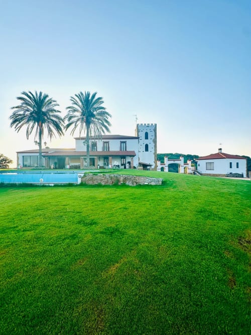 Casa Gestyp-AT en Mérida con edificios blancos, torre azul, palmeras, piscina y vistas a la montaña