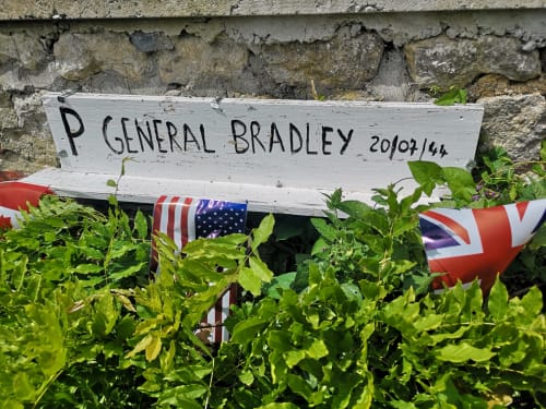 Memorial plaque for General Bradley with American and British flags at Au Gite d'Isigny, Normandy