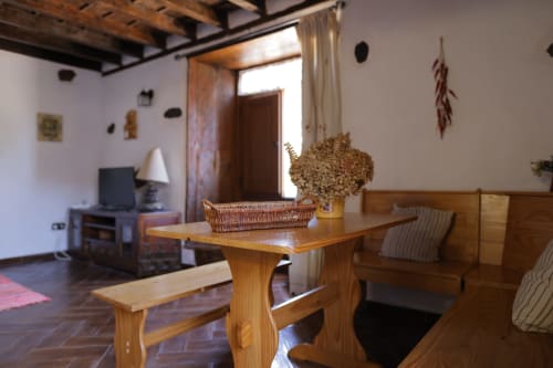 Rustic cottage living room with wooden furniture, fireplace, and mountain views at Casonas de Marengo, Icod de los Vinos