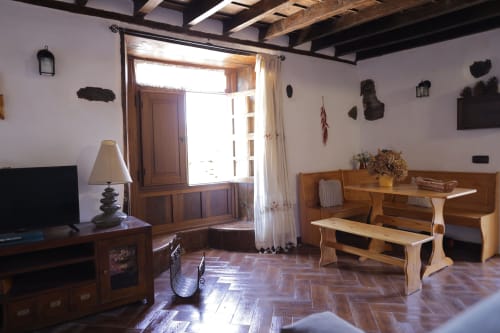 Rustic cottage living room at Casonas de Marengo with wooden beams, terracotta floors, and sea views