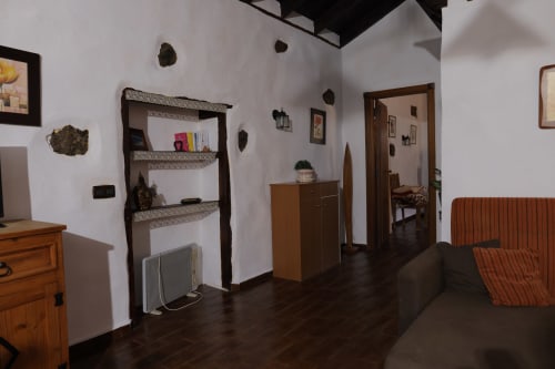Rustic cottage living room at Casonas de marengo with wooden furniture, white walls, and mountain view decorations