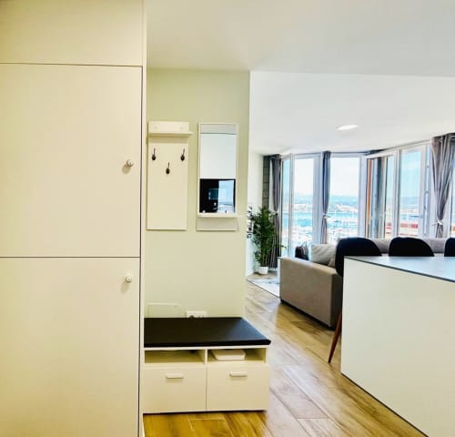 Apartamento moderno en Holibai Baiona con vista al mar, cocina abierta, sala de estar y ventanales panorámicos con vistas a la costa