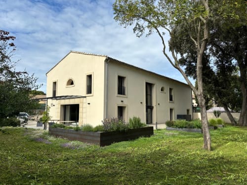 Modern cream villa Les FOUDRES at La Conciergerie De Franck in Boissieres with landscaped gardens and tall trees