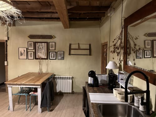 Cocina y comedor de la casa rural Casa Tapiolas en Molló, Girona con vigas de madera rústica y decoración con vistas a la montaña
