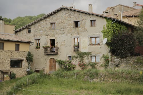 Casa de piedra rústica Casa Tapiolas en Molló, Girona con muros cubiertos de hiedra y vistas a las montañas