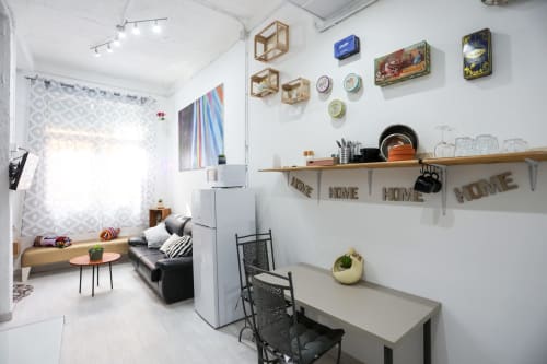 Luminoso estudio en Apartamentos Huelintown Málaga con cocina americana, cama, sofá y vistas a la ciudad