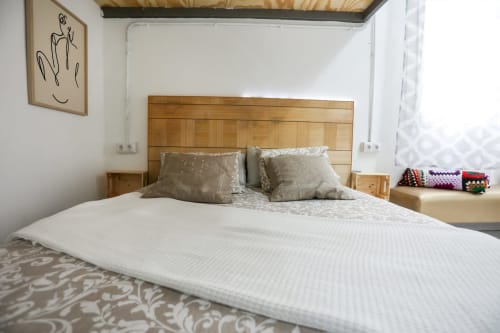 Dormitorio moderno en Apartamentos Huelintown, Málaga, con cabecero de madera, ropa de cama blanca y decoración contemporánea
