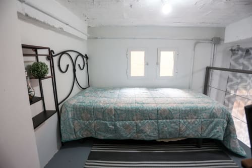 Dormitorio en Apartamentos Huelintown, Málaga, con cama matrimonial, cabecero de hierro forjado y vistas a la ciudad