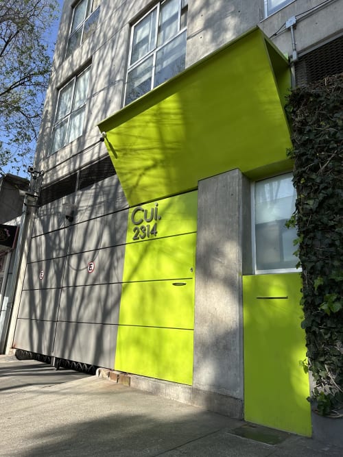 Entrada de tienda en verde lima brillante en la propiedad de apartamentos Pares Homes en la Ciudad de México con diseño arquitectónico moderno