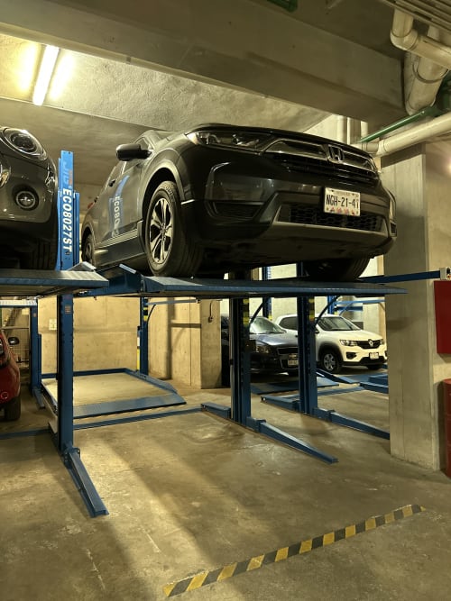 SUV negro estacionado en elevador de garaje multinivel del edificio de departamentos Pares Homes en Ciudad de México