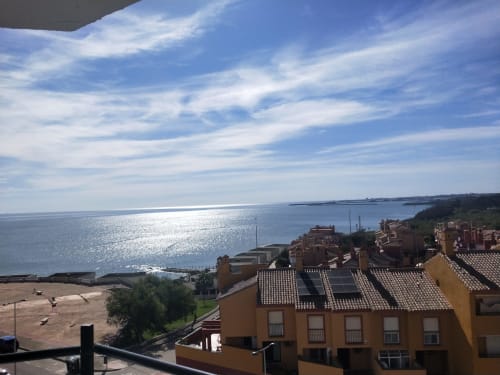 Vista del balcón de apartamento junto al mar con vistas a la playa Puerto Santa María y el Mar Mediterráneo con edificios de terracota