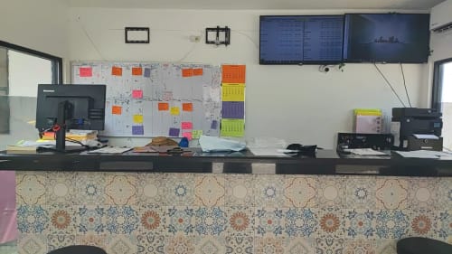 Mostrador de recepción del Hotel Estrella en Matamoros con tablero de horarios organizado y monitores de computadora
