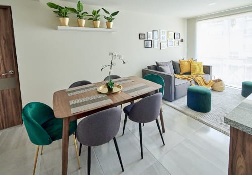Apartamento moderno en CDMX con sillas de terciopelo turquesa, mesa de madera y sofá gris en Pares Homes
