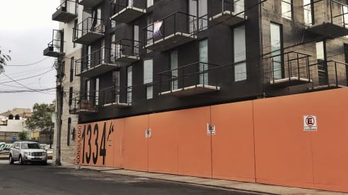 Edificio de departamentos moderno con valla de construcción naranja en Pares Homes, ubicación en Ciudad de México