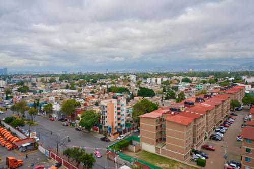 Vista aérea del departamento en CDMX de Pares Homes mostrando el paisaje urbano con edificios y cielo nublado