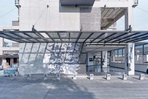Entrada de departamento Pares Homes en CDMX con pérgola, arte geométrico mural y vistas de la ciudad