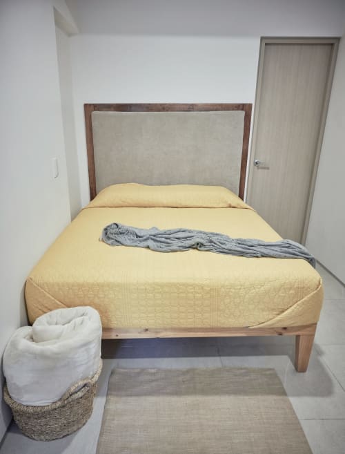 Recámara moderna en Pares Homes, CDMX con cama acolchada amarilla, cabecera tapizada y canasta tejida para almacenaje