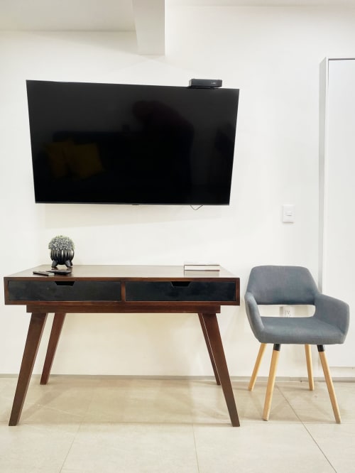 Espacio de trabajo moderno en apartamento de Pares Homes CDMX con TV montado en pared, escritorio de madera y silla gris