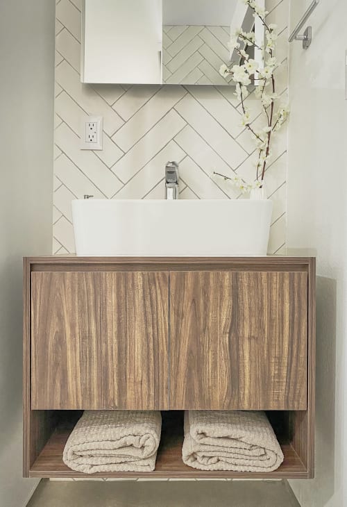 Vanidad moderna de baño con gabinetes de madera y lavamanos blanco de recipiente en apartamento Pares Homes de la Ciudad de México