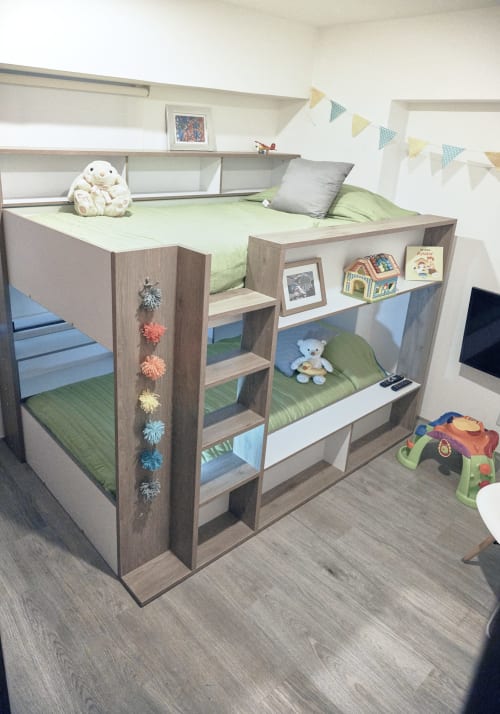 Moderna cama litera tipo loft con ropa de cama verde, estantes de almacenamiento y juguetes infantiles en departamento CDMX de Pares Homes