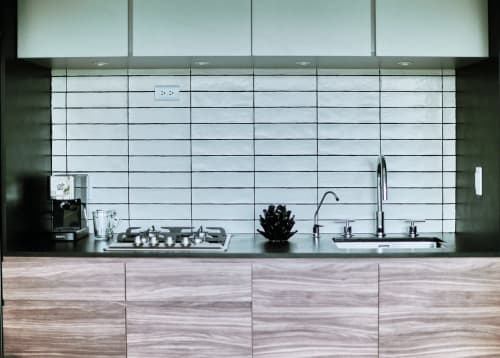 Cocina moderna con azulejos blancos tipo metro, electrodomésticos de acero inoxidable y gabinetes de madera en apartamento Pares Homes