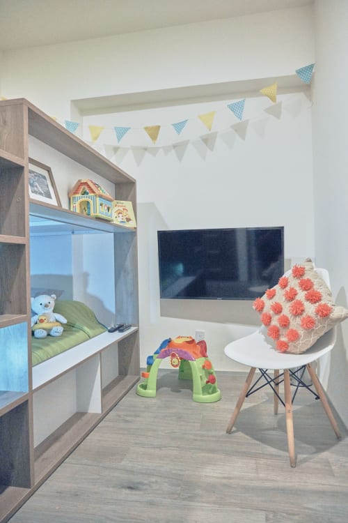 Recámara infantil moderna en Pares Homes CDMX con rincón de juegos, TV, banderines y juguetes coloridos