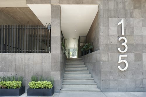 Entrada moderna de hormigón del apartamento Pares Homes en Ciudad de México con escaleras, barandas metálicas y dirección contemporánea