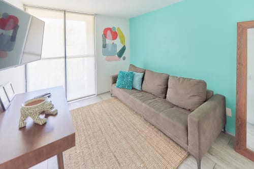 Sala moderna en Pares Homes CDMX con paredes turquesas, sofá gris e iluminación natural