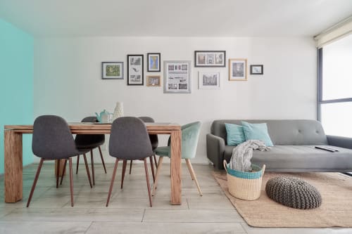 Sala moderna de apartamento en CDMX con comedor, sofá gris, acentos turquesas y galería en Pares Homes