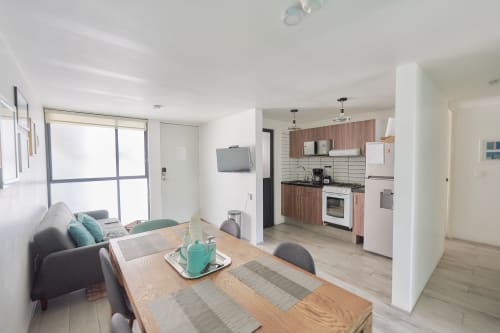 Departamento moderno en CDMX de Pares Homes con cocina abierta, comedor y sala con vistas a la ciudad