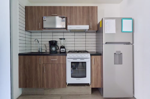 Cocina moderna en apartamento de Pares Homes, Ciudad de México, con gabinetes de madera, electrodomésticos blancos, backsplash de azulejos y