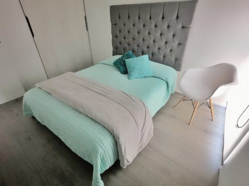 Recámara moderna en Pares Homes CDMX con ropa de cama menta, cabecera tapizada gris, silla blanca y decoración minimalista