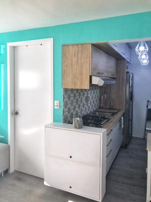 Cocina de apartamento moderno en Ciudad de México con paredes turquesas, gabinetes blancos y azulejos geométricos en Pares Homes