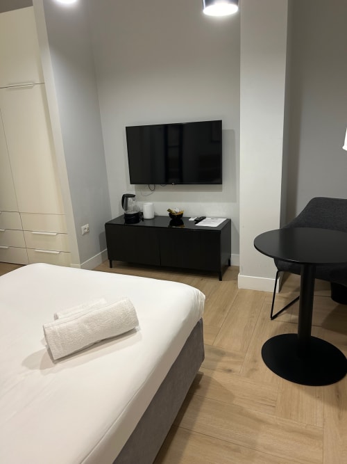Camera moderna di Casa Lounge Istria a Cagliari con letto, TV a schermo piatto, arredamento nero e vista città