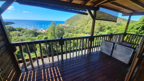 Terrasse couverte en bois avec vue sur mer de la villa Les Hauts De Deshaies en Guadeloupe
