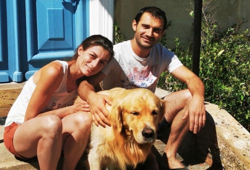 Two guests with golden retriever at Baccara Lodge, Arengosse, France. Sunny courtyard moment.