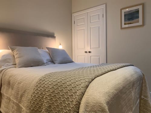 Grapevine Studio bedroom in Waterbeach, Cambridge with double bed, neutral décor, white wardrobe, and framed landscape