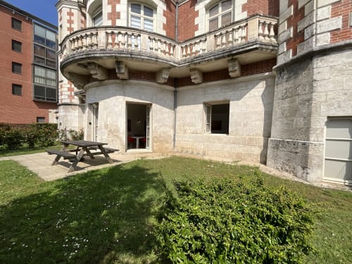 Gîte La Chocolaterie garden view at Locacharme in Blois, France with patio seating and historic stone building