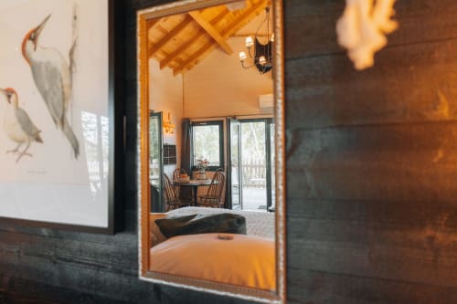L'espace de vie de la cabane se reflète dans le miroir | Hébergement Insolite avec Jacuzzi
 