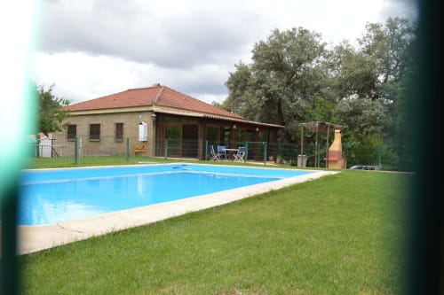 Villa Casa Rural Ribera del Hueznar en Constantina con piscina azul, casa de ladrillo, terraza y vistas a la montaña