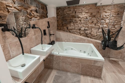 Découvrez la Love Room 3, une suite romantique idéale pour une escapade en couple. Avec ses magnifiques murs en pierre apparents, cette chambre offre une ambiance chaleureuse et authentique. Profitez d'une double vasque moderne et d'un grand écran TV avec Netflix pour vos soirées détente. Le clou du séjour ? Une superbe baignoire à balnéothérapie pour deux, parfaite pour un moment de relaxation absolue. Réservez la Love Room 3 et vivez une expérience inoubliable.